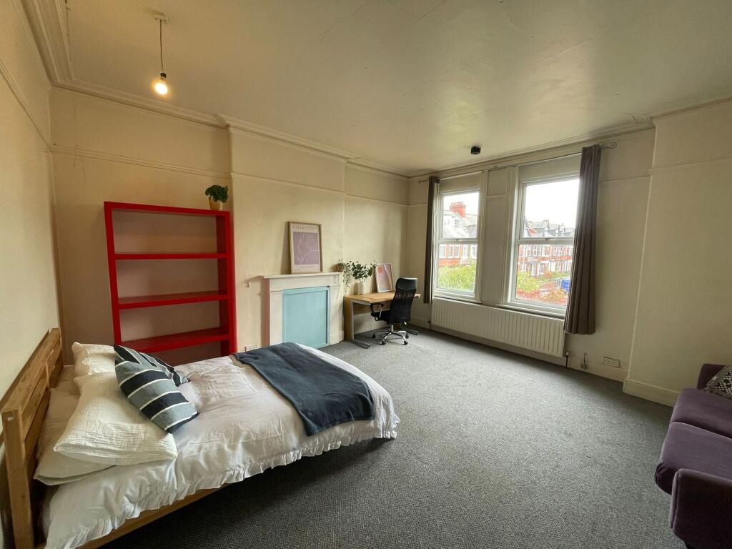 A spacious and well-lit living area with large ...