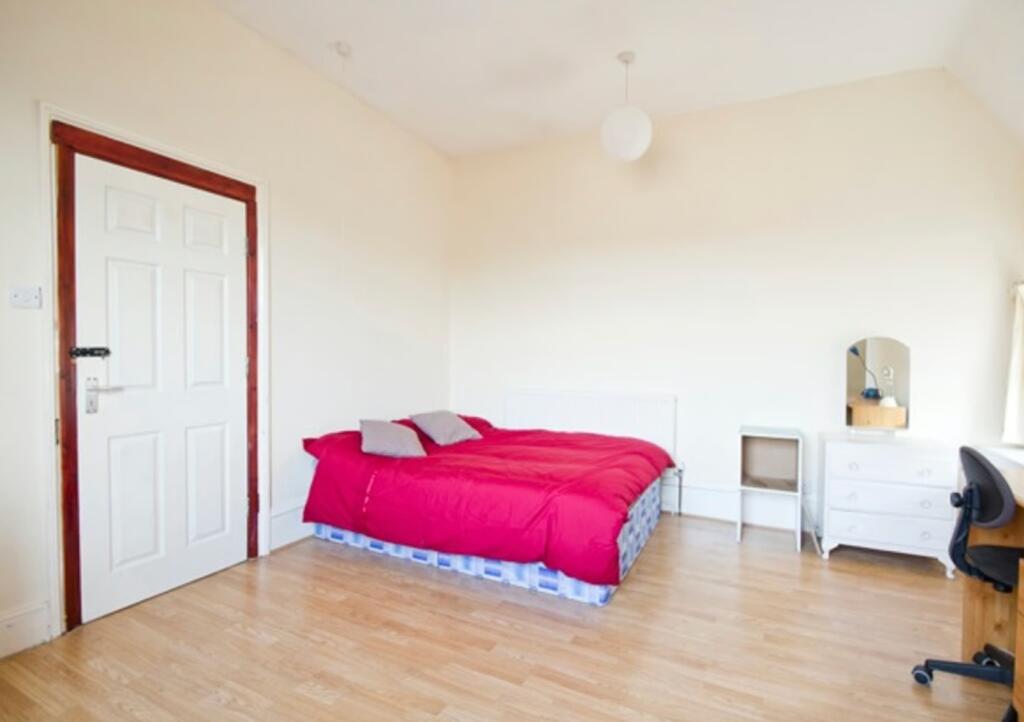 A spacious and bright double bedroom featuring ...