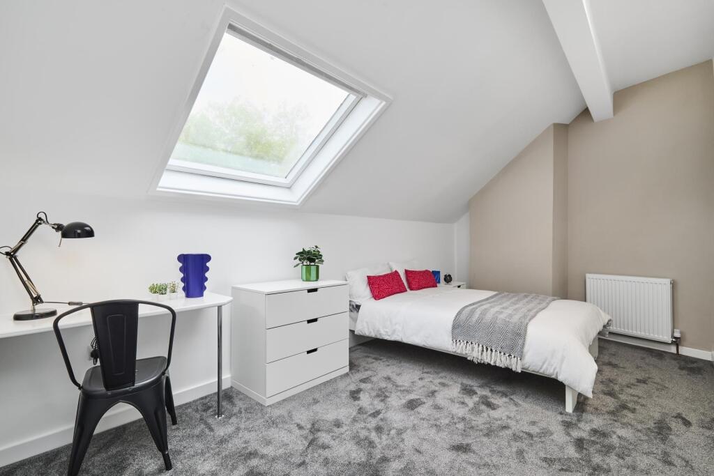 A bright and cozy single bedroom with a comfort...