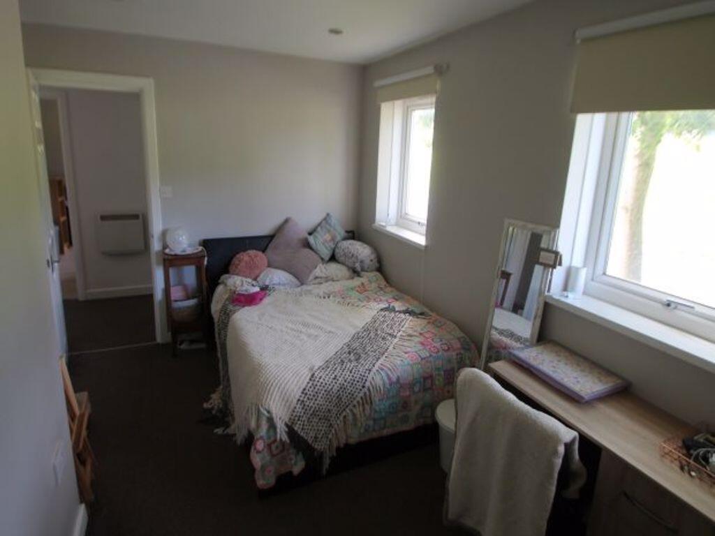A tidy and well-maintained small bedroom with a...