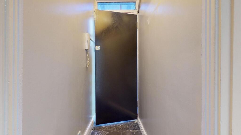 A narrow hallway with clean, neutral-colored wa...