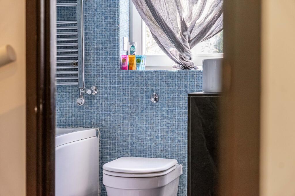 Bright bathroom featuring a white toilet and ba...