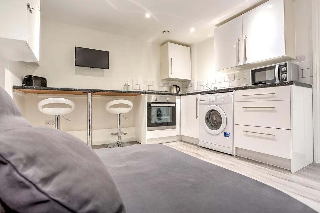 Modern and clean kitchen with white cabinetry a...