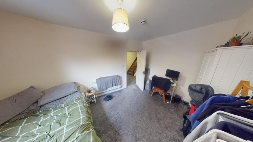 A cozy single bedroom featuring a comfortable b...