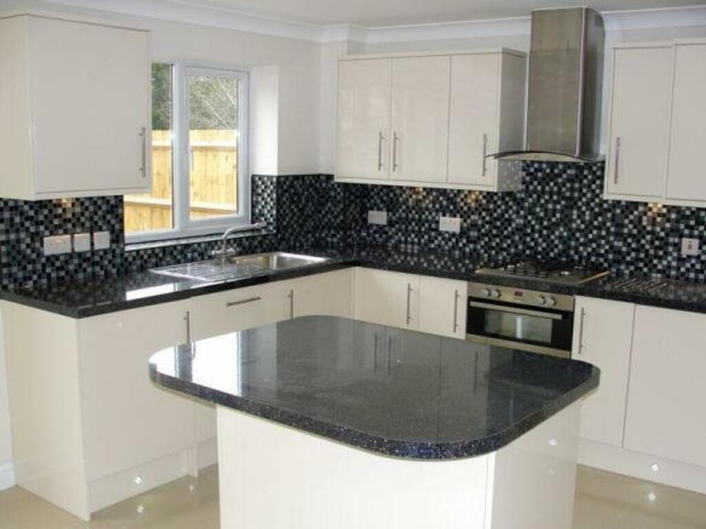 This modern kitchen features stylish cabinetry,...