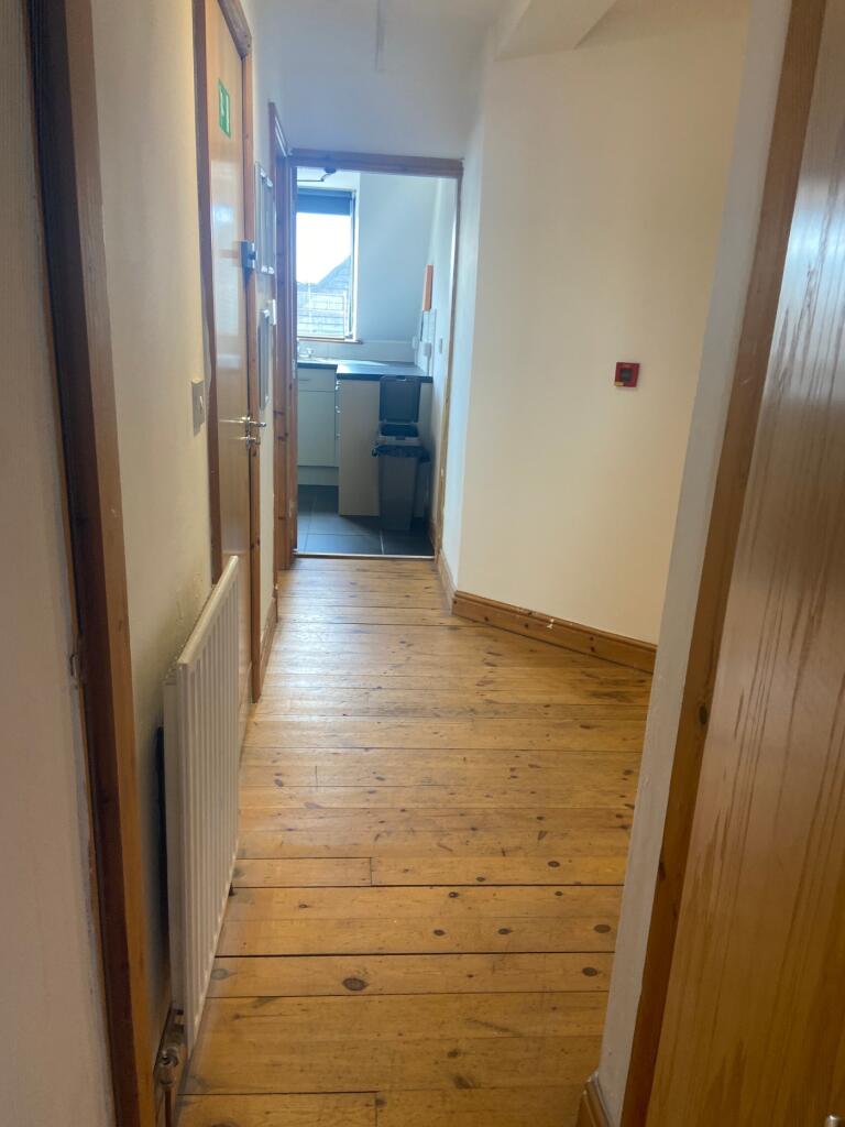 A bright and tidy hallway with wooden flooring,...