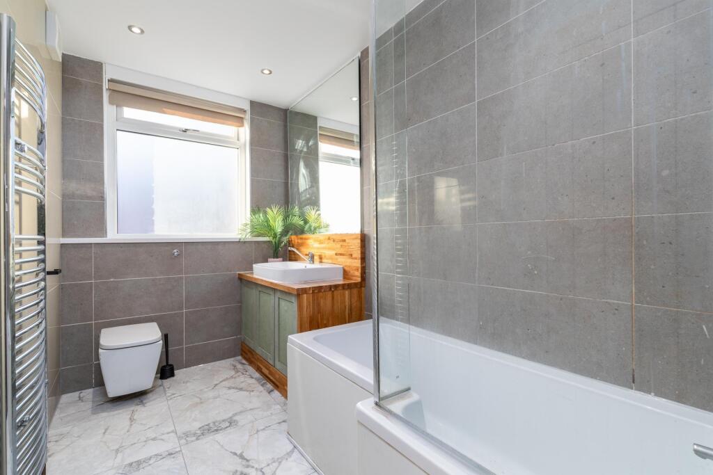 Bright, modern bathroom with a bathtub and inte...