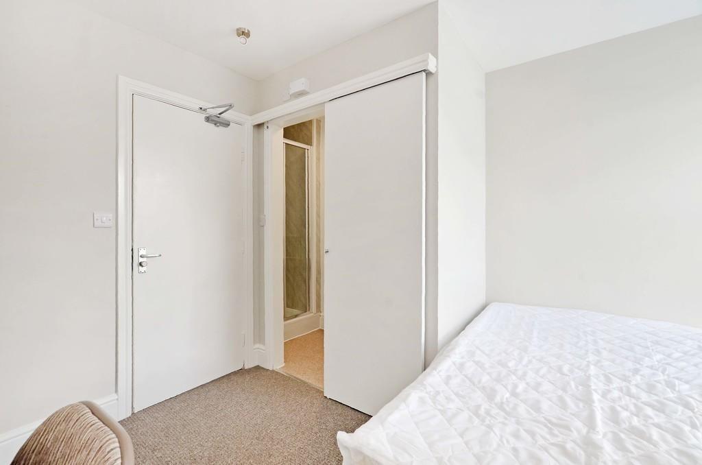 A clean and bright single bedroom featuring neu...
