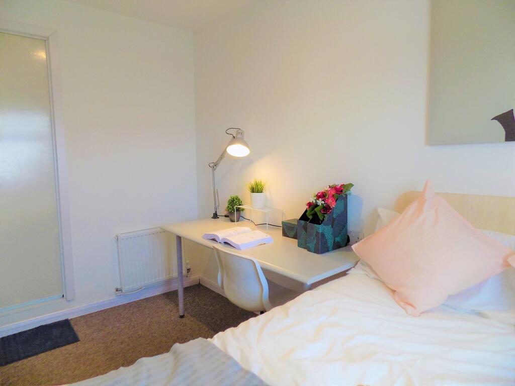 A neat and cozy single bedroom featuring a comp...