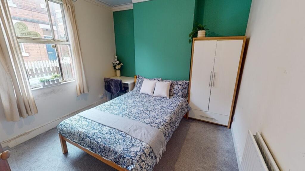 This inviting double bedroom features a cozy be...