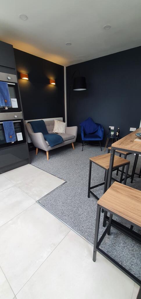 A stylish communal lounge featuring modern furn...