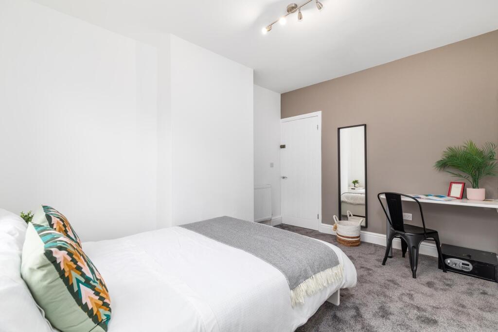 Bright, tidy double bedroom with a made bed, ne...