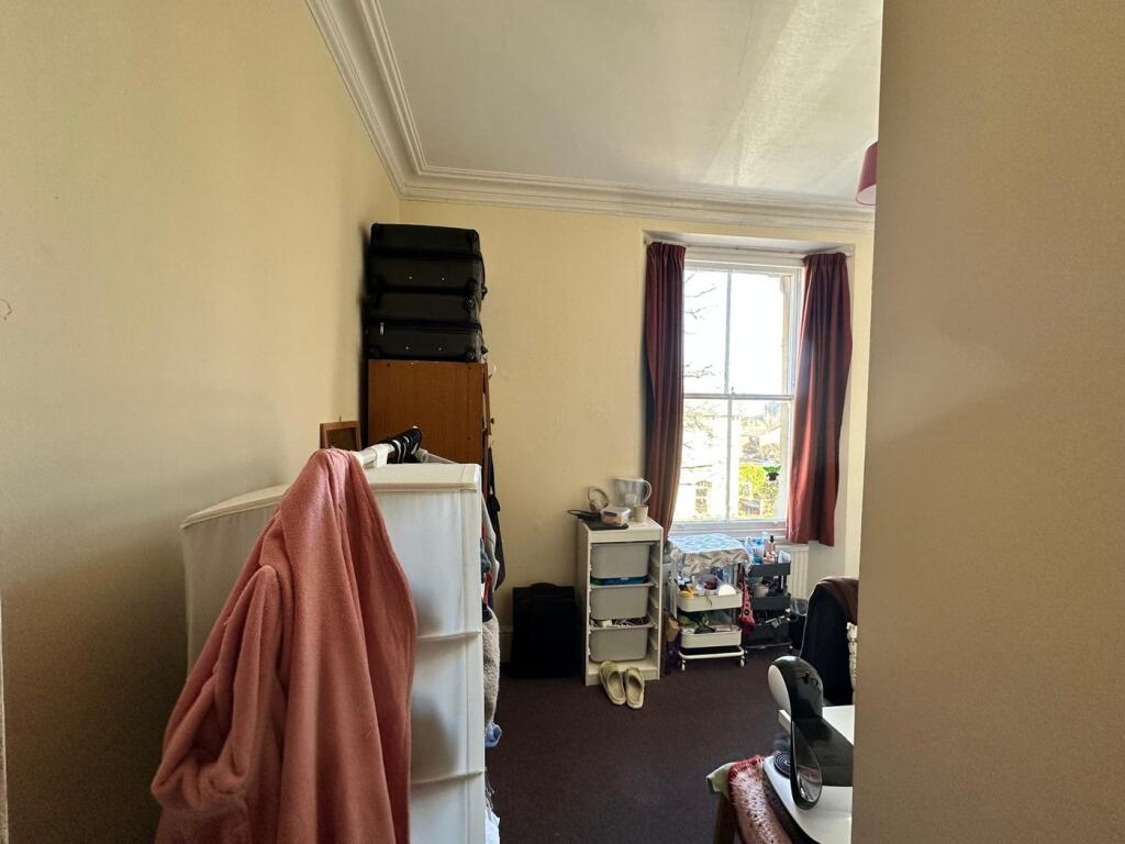 A cozy double bedroom featuring a good-sized wi...