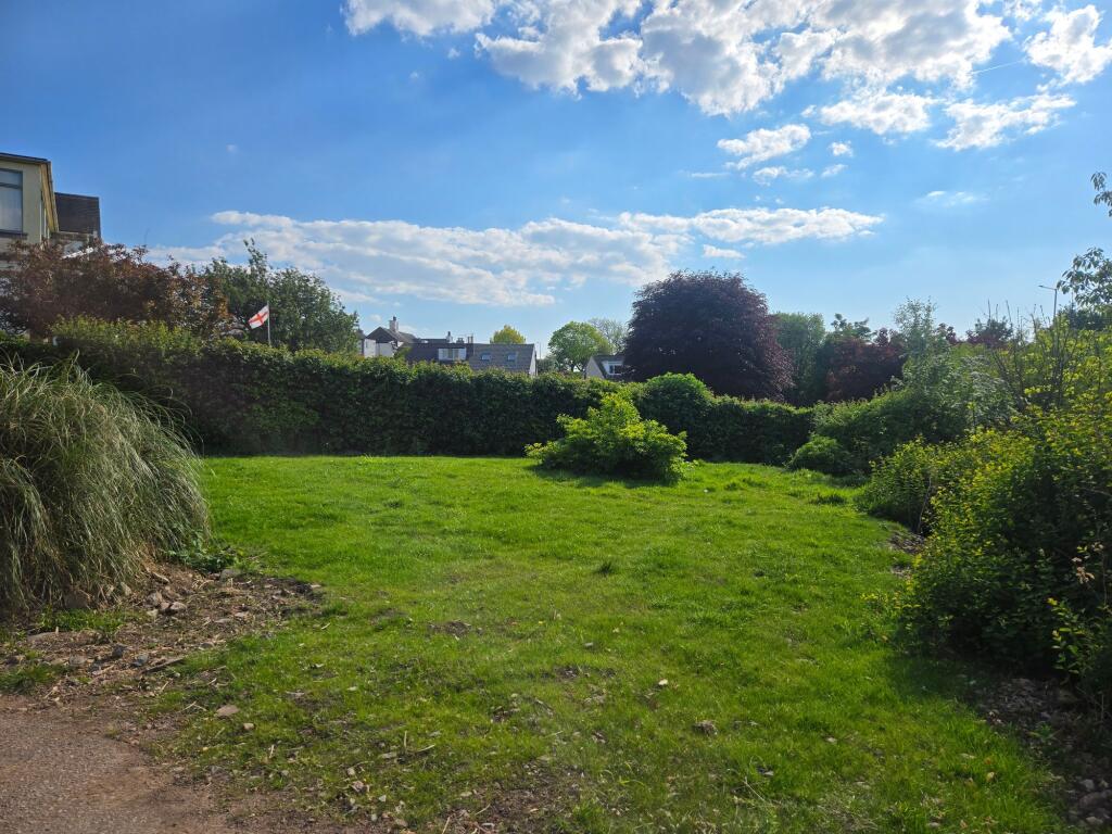 The front garden is situated adjacent to the driveway.