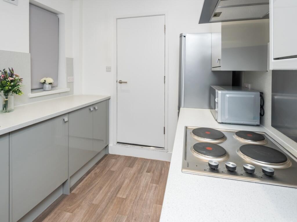 A modern and tidy kitchenette with ample counte...