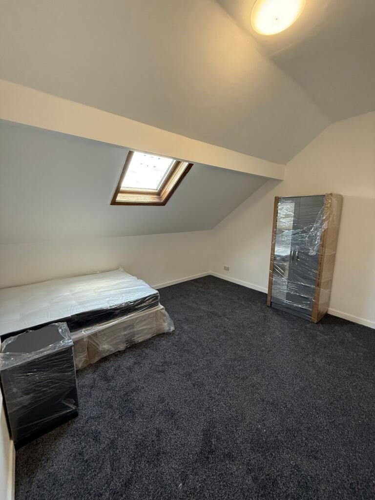 A cozy attic bedroom featuring a skylight windo...