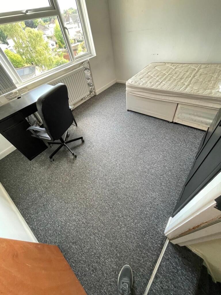 Cozy double bedroom featuring a practical desk ...