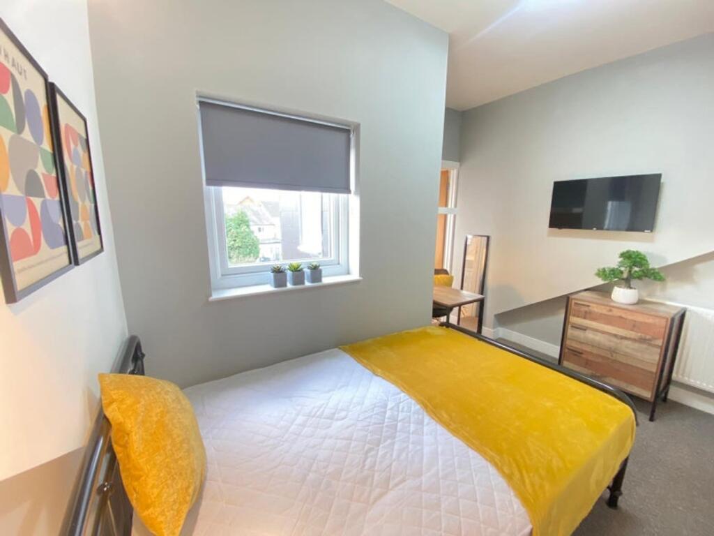 This inviting double bedroom features a cozy ye...