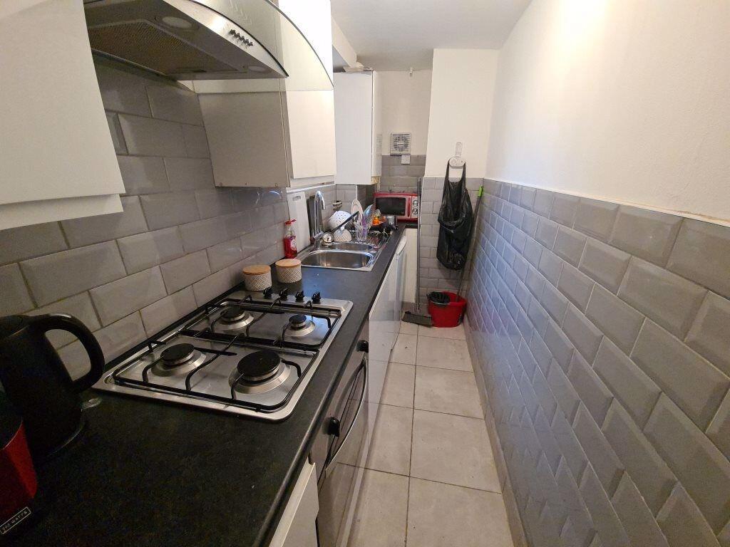 Bright, modern galley kitchen with tiled splash...
