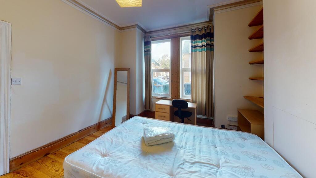Bright double bedroom featuring a large window ...
