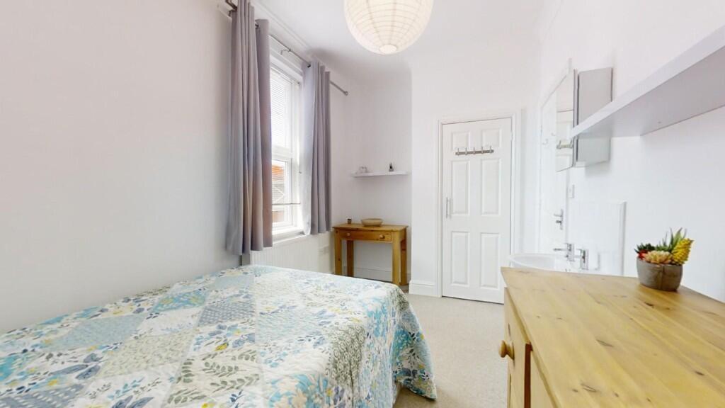 Bright and cozy single bedroom featuring a comf...