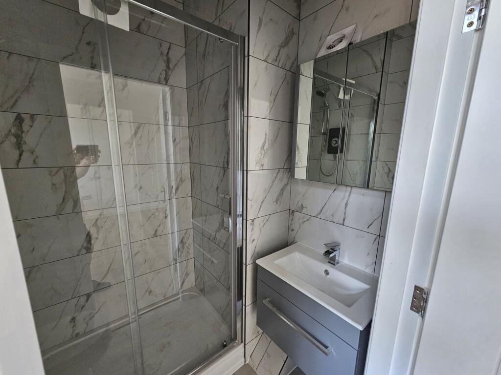 Modern bathroom with a large glass-enclosed sho...
