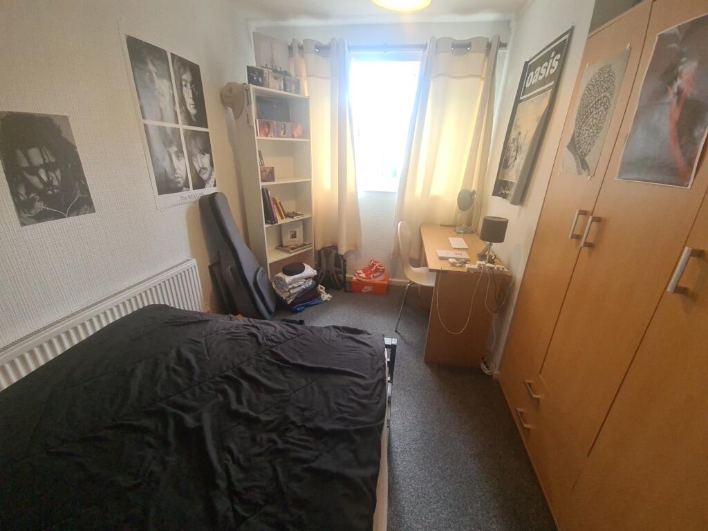 A cozy single bedroom featuring a neatly made b...