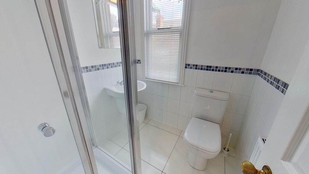 Bright, modern bathroom with white tiles, a wal...