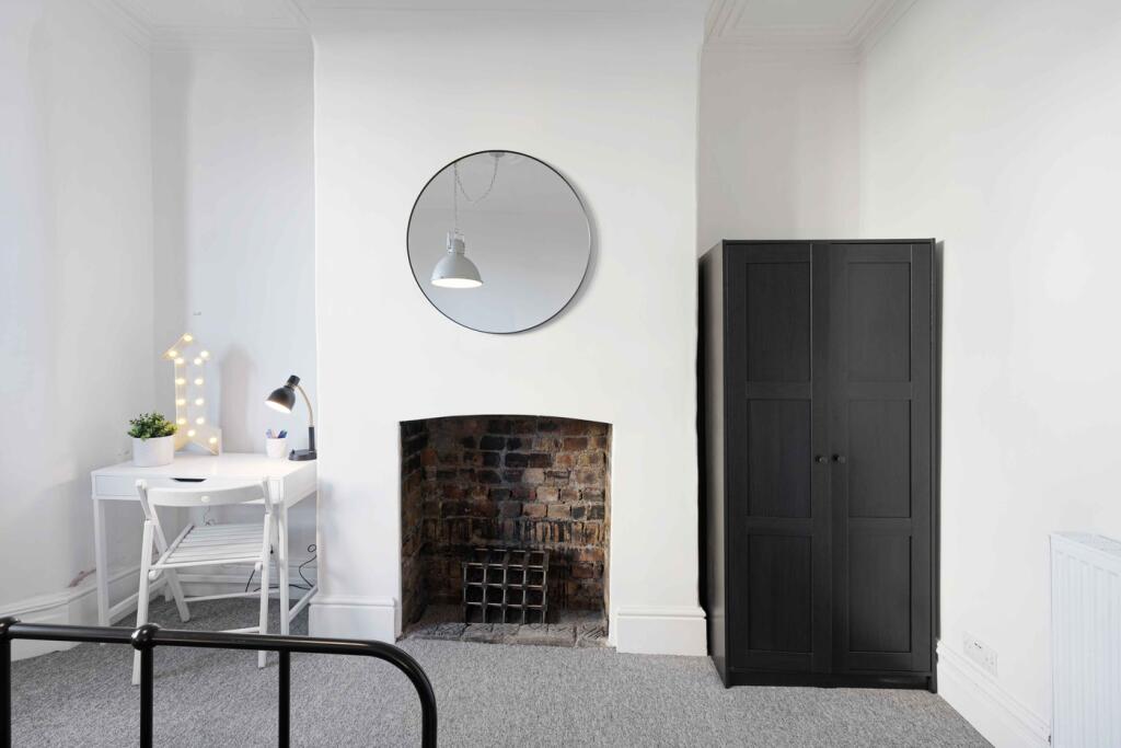 A bright and tidy double bedroom featuring a st...