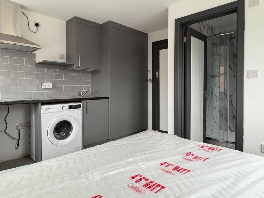 Bright, modern studio bedroom with integrated k...