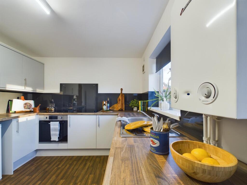A modern and tidy kitchenette with ample natura...