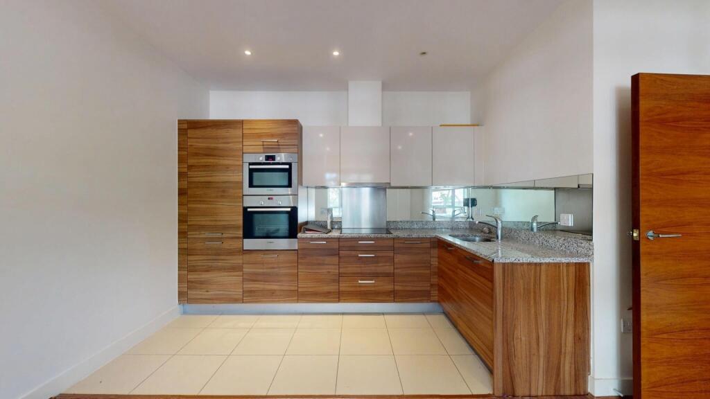 A modern kitchen featuring stylish wood cabinet...
