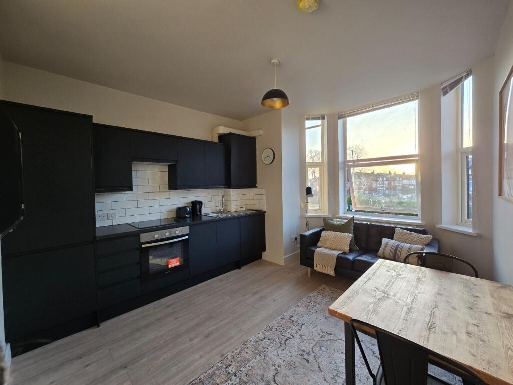 Bright open-plan living area with modern fitted...