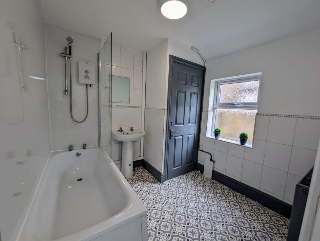 A bright and clean bathroom featuring a white b...