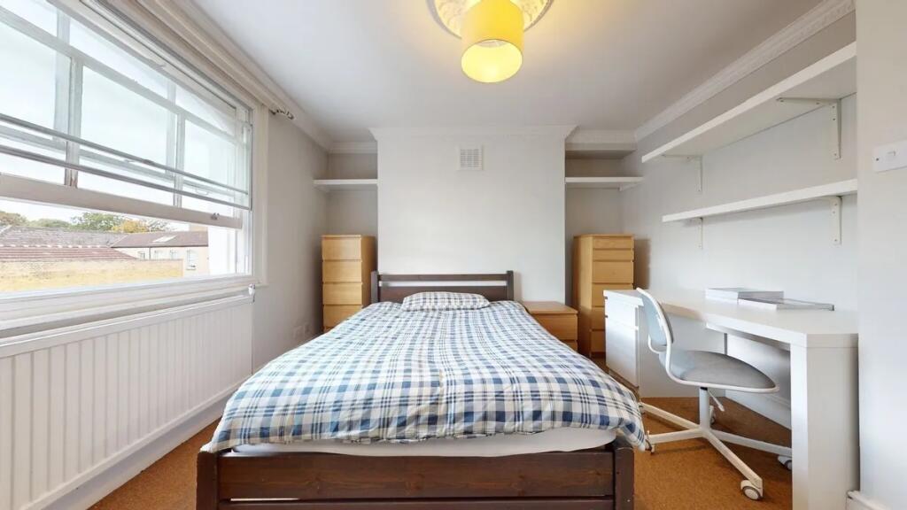 A bright and tidy double bedroom featuring a co...