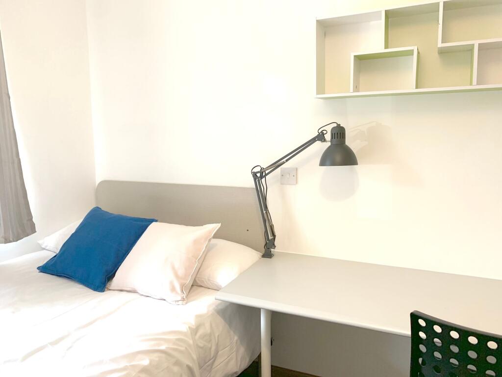 A bright and tidy single bedroom featuring a co...