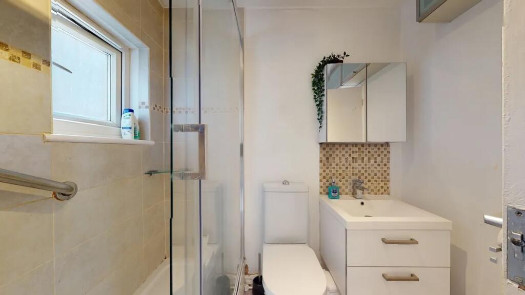 A modern bathroom featuring a clean white vanit...
