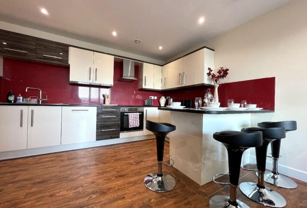 A sleek, modern kitchen featuring a stylish red...