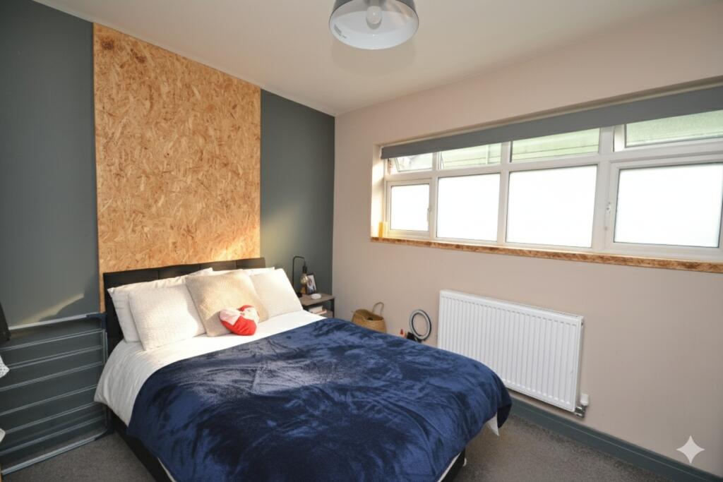 A cozy double bedroom with a comfortable bed, s...