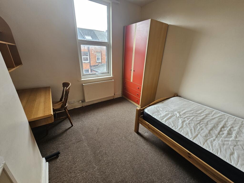 A neat and functional single bedroom featuring ...