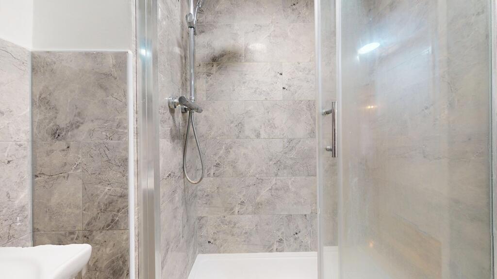 Modern bathroom featuring a spacious shower are...