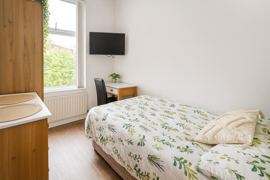Bright and tidy double bedroom featuring a flor...