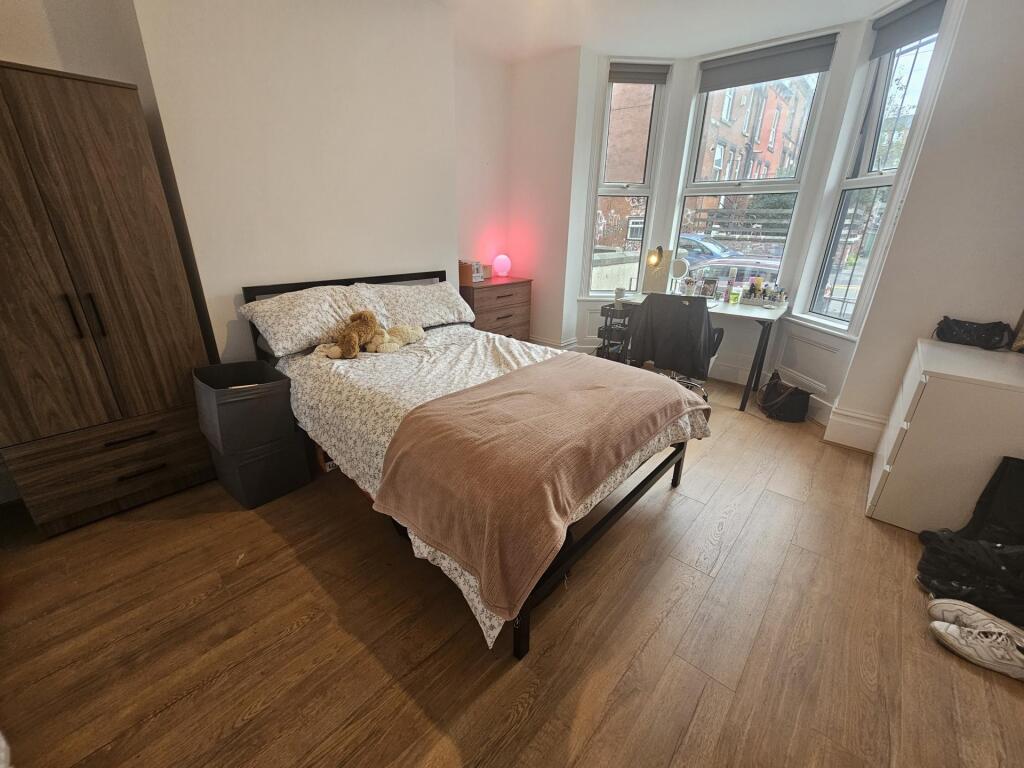 A spacious and well-lit master bedroom featurin...