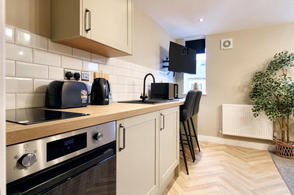 A modern kitchen featuring sleek cabinetry, amp...