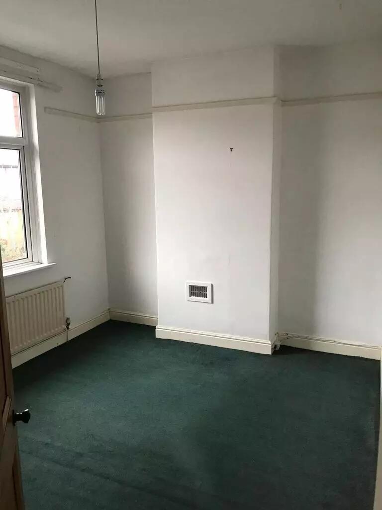 A simple, clean single bedroom featuring a larg...