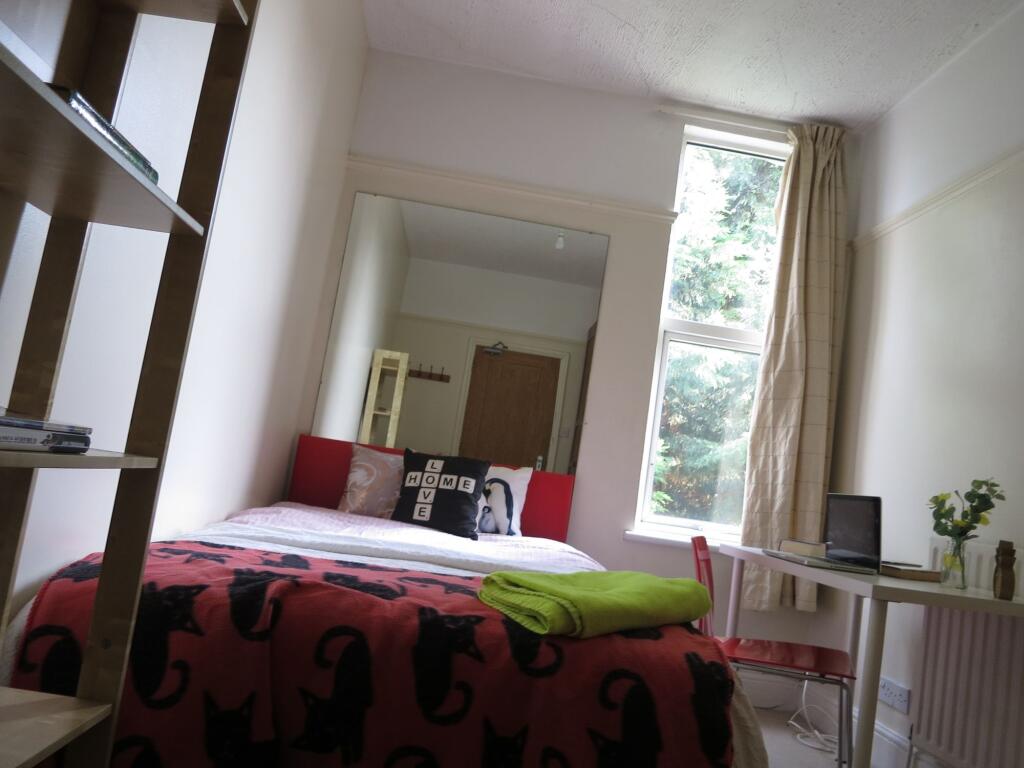 A cozy bedroom featuring a double bed with a co...