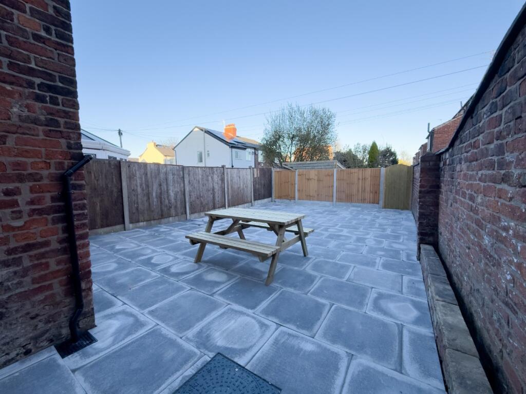 Private paved courtyard with a central picnic b...
