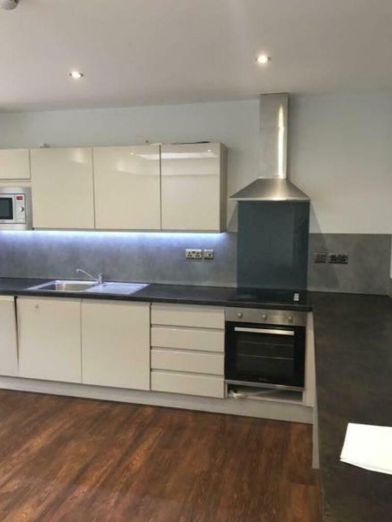 Modern kitchen with sleek white cabinetry, inte...