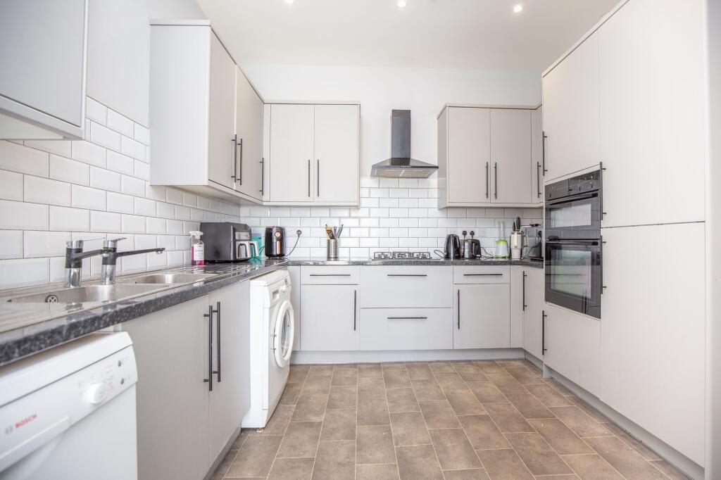 Bright and modern kitchen featuring ample cabin...