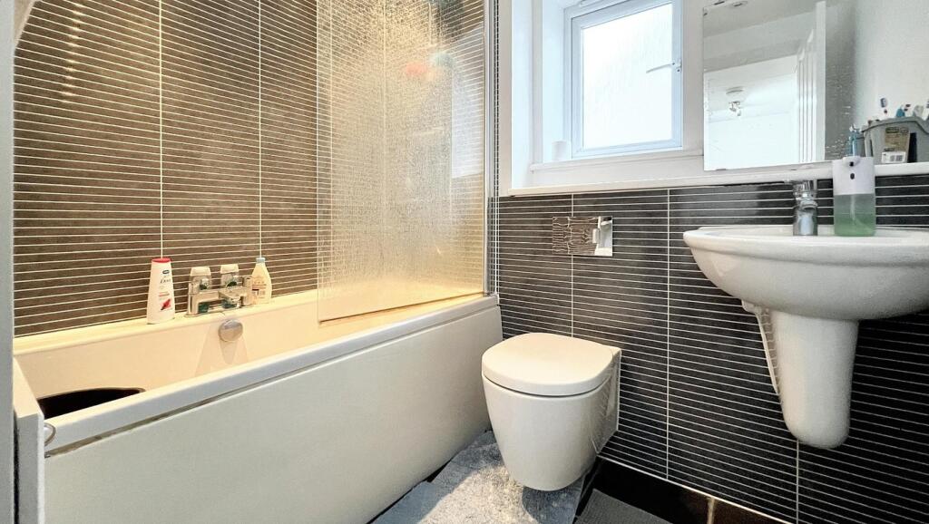 A well-maintained bathroom featuring a bathtub ...